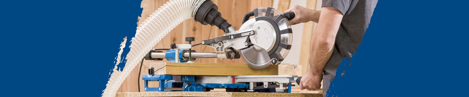 Ein Mann bedient eine Kappsäge von Scheppach. Die Säge ist mit einem Staubsauger verbunden.