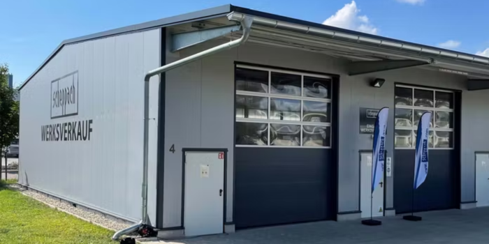Scheppach Werkverkauf-Gebäude mit Fahrzeugschleuse und Werbung für Werkzeugverkauf