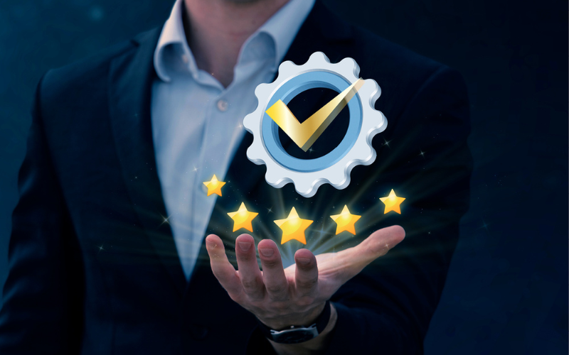 Ein Mann in Anzug hält ein Logo mit einem Häkchen und fünf Sternen in der Hand. Das Logo symbolisiert Premium-Service oder -Kundenzufriedenheit.
