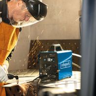 Ein Arbeiter schneidet mit einem Plasmaschneider von Scheppach Metall. Im Hintergrund ist das 3in1 Kombi-Schweißgerät WSE4000-CUT zu sehen.