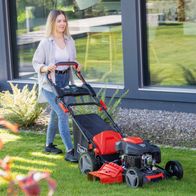 Person mit Scheppach-Benzinrasenmäher MS200-51E (DIY) beim Einsatz im Garten