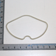 Zylinderkopfdichtung, oval geformt, neben einem Lineal zur Größenveranschaulichung.