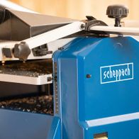 Abricht- & Dickenhobelmaschine HMS1070 Scheppach, Detailansicht von vorne mit Messskala und Staubabsaugung.