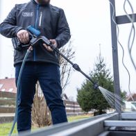 Scheppach Akku-Hochdruckreiniger mit Schlauch und Düse beim Einsatz auf Außenwand