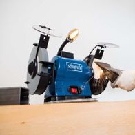 Scheppach Doppelschleifer BG200AL im Einsatz. Ein Handschuh schützt die Hand beim Schleifen. Die Maschine wird von oben gezeigt.