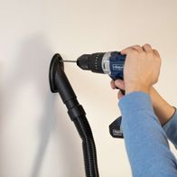 Absaugdüse für Scheppach-Absauganlage mit Bohrer, dargestellt beim Einsatz an einer Wand