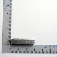 Eine Passfeder neben einem Lineal zur Größenveranschaulichung. Die Passfeder ist von vorne zu sehen.