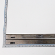 Hobelmesser HSS 260x17.5x2.9mm 2 Stück. Gezeigt von der Seite. Messskala im Hintergrund.