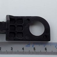 Ein schwarzes Gelenkteil mit Loch und mehreren Vertiefungen, von der Seite betrachtet.