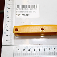 Ein gelber Schalterknopf mit zwei Löchern, Teilnummer 170, Artikelnummer 3901216047. Der Schalterknopf liegt auf einem Lineal und ist von der Seite zu sehen.