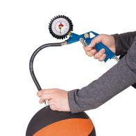 Ein Scheppach-Kompressor wird verwendet, um einen Basketball aufzublasen. Der Kompressor hat einen Druckmesser und einen blauen Griff. Der Ball ist schwarz und orange.