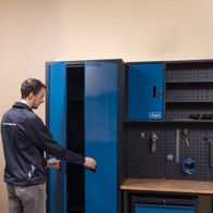 Der Werkstattwagen mit blauer Tür und Werkzeugwand bietet viel Stauraum und Organisation. Inklusive Werkbank und Modulsystem für individuelle Anpassung. Maße: 2360x500x2050mm.