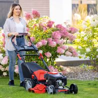 Männer oder Frau beim Einsatz eines Scheppach-Rasenmähermodells mit Radantrieb und E-Start-Funktion, zeigt typische Produktmerkmale.