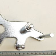 Spannplatte für Riemen, Ansicht von oben. Die Spannplatte hat drei Löcher und zwei Bolzen. Die Spannplatte ist 12 cm lang und 9 cm breit.
