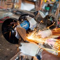 Scheppach dual-angle grinder with LED lighting showing sparks and debris ejection