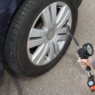 Ein Scheppach-Kompressor wird verwendet, um den Reifendruck eines Autos zu prüfen. Der Kompressor ist mit einem Druckmesser ausgestattet.