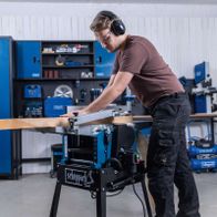 Scheppach-Hobelmaschine HMS1500 mit fahrbarem Untergestell, Detailansicht beim Abrichten und Dicken von Holzplatten