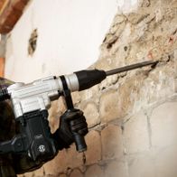 Scheppach-Bohrhammer RBH1600M mit SDS-Max-Bohrkopf, Handgriff und Arbeitsposition beim Arbeiten