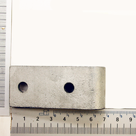 Ein weißes Schwenklager mit zwei Löchern, von oben fotografiert. Die Maße sind 6,5 cm lang und 3 cm breit.