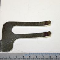 Ein Werkstückniederhalter von Scheppach neben einem Lineal zur Größenveranschaulichung. Der Niederhalter ist von der Seite zu sehen.