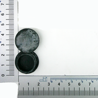 Ein Stopfen neben einem Lineal zur Größenveranschaulichung. Der Stopfen ist rund und hat einen Durchmesser von etwa 2,5 Zentimetern.