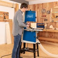 Ein Mann bedient eine Bandsäge BASA3 von Scheppach in einer Werkstatt. Die Säge hat eine maximale Durchlasshöhe von 205 mm und eine Durchlassbreite von 306 mm.