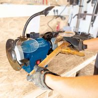 Der Scheppach Doppelschleifer BG200 verfügt über eine flexible Schleifhaube und einen robusten Holzgriff für sicheren Halt. Die Maschine ist mit einem effektiven Staubabsaugsystem ausgestattet.