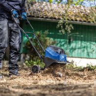 Akku-Bodenhacke mit Arbeitsgerät in Aktion, die Bodenaufbereitung zeigt