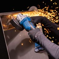 Handwerkskraft beim Arbeiten mit Akku-Winkelschleifer, sparkerfreie Bearbeitung