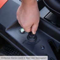 Einfaches Starten durch E-Start oder Seilzugstart. Der Knopf ist mit einem grünen Symbol und dem Text 'START' beschriftet. Der Knopf ist in die Mittelkonsole des Aufsitzrasenmähers integriert.