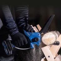 Akku-Gehölzschneider mit Schutzhandschuhen beim Arbeiten an Holzstück