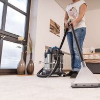 Eine Person reinigt mit dem Scheppach SprayVac20 einen Teppich. Der Staubsauger ist ein 5in1 Wasch-, Nass- und Trockensauger mit 20L Behälter.