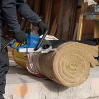 Elektro-Universalsäge mit Scheppach-Motor, Sägeblatt und Arbeitsstellung beim Schneiden von Holzstämmen