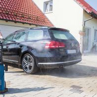 Ein Mann wäscht ein Auto mit dem Hochdruckreiniger HCE2000 von Scheppach. Der Reiniger hat 153 bar Druck und 2000W Leistung.