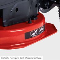 Einfache Reinigung dank Wasseranschluss. Der Scheppach Benzin-Aufsitzrasenmäher MR235-61 bietet einen praktischen Wasseranschluss für die einfache Reinigung des Geräts. Die Illustration zeigt die Reinigungsfunktion und den Auffangbehälter.