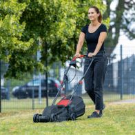 Frau mit Scheppach-Elektrorasenmäher im Einsatz auf grünem Rasen