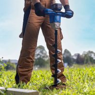 Person beim Einsatz eines Akku-Erdbohrers in der Landwirtschaft oder Gartenarbeit