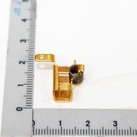 Kohlebürstenhalter neben einem Lineal zur Größenveranschaulichung. Der Kohlebürstenhalter ist von der Seite zu sehen.