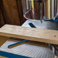 Scheppach Tischbohrmaschine mit Laserausrichtung und variabler Geschwindigkeit beim Arbeiten an Holzstück