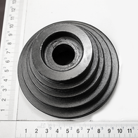 Riemenscheibe Ø100 von Scheppach. Die Scheibe hat konzentrische Rillen und einen zentralen Durchgang. Sie liegt auf einem Lineal mit Millimeter- und Zollskala.