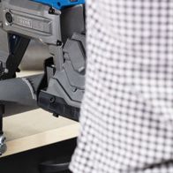 Metallbandsäge MBS1200xt Scheppach, seitliche Ansicht. Die Bandsäge ist auf einem Werkstück befestigt.