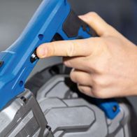 Metallbandsäge MBS1200xt Scheppach von vorne. Hand greift nach dem Schalter.