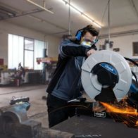 Ein Arbeiter verwendet den Trennschneider MT140 von Scheppach in einer Werkstatt.