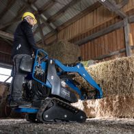 Scheppach Kompaktlader mit Greifwerkzeug und Ballenspieß, im Einsatz auf einer Schüttfläche