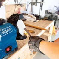 Scheppach-Doppelschleifer mit Arbeitsplatte und Handschuh in Werkstattumgebung
