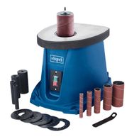 Spindelschleifmaschine OSM100 von Scheppach mit 24-teiligem Schleifhülsen-Set. Gezeigt von vorne mit verschiedenen Schleifhülsen und Zubehörteilen.