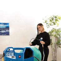 Mobiler Kompressor Air Force2 von Scheppach, 220-240V 50Hz 1100W, mit Schlauch und Aufblasnadel, eine Person bläst einen Gymnastikball auf.