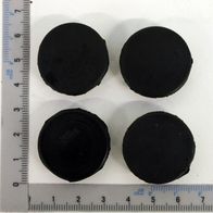 Ein Satz von vier schwarzen Stopfen für Seitenteile, jeweils mit einem Durchmesser von etwa 5 cm, wie auf einem Lineal gemessen.