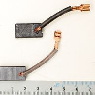 Kohlebürsten-Set mit zwei Stücken, jeweils 6,5 x 11 x 21 mm, neben einem Lineal zur Größenveranschaulichung.