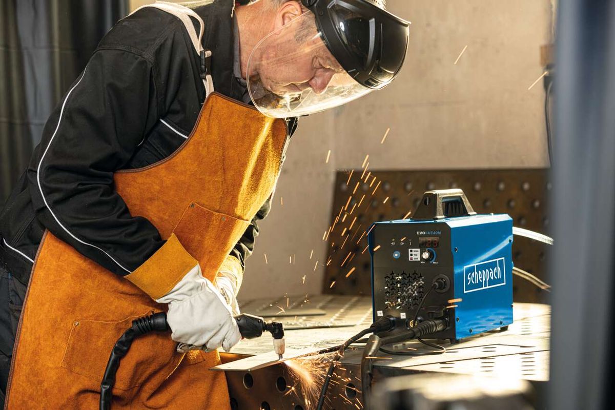 Ein Arbeiter schneidet mit einem Plasmaschneider von Scheppach Metall. Im Hintergrund ist das 3in1 Kombi-Schweißgerät WSE4000-CUT zu sehen.